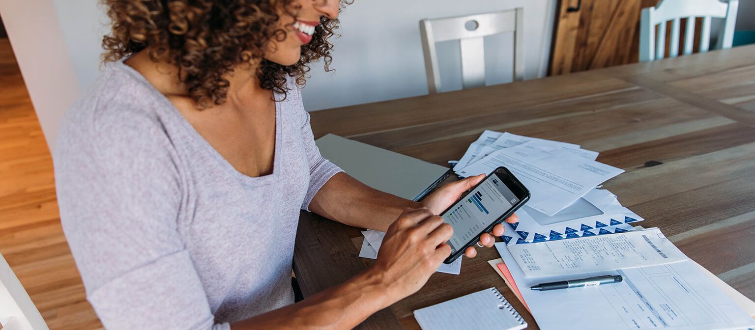 Woman paying bills on mobile phone