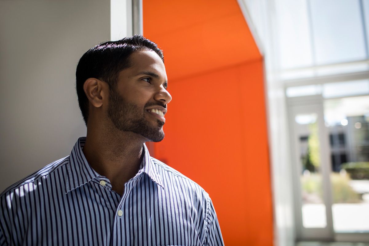 a man standing in front of an orange wall