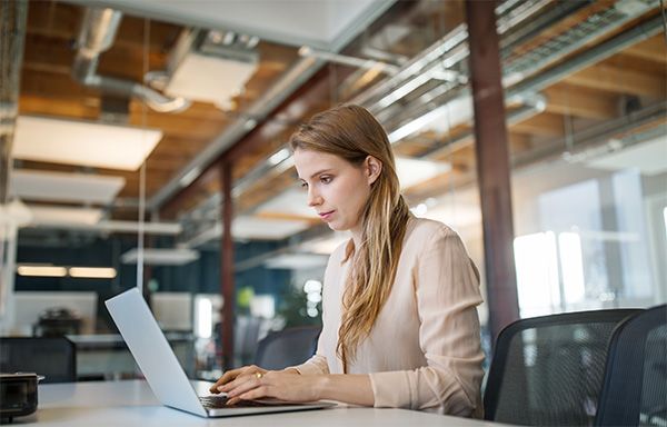 women in modern office working on laptop