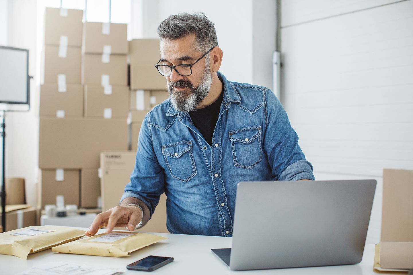 small business owner surrounded by shipping boxes