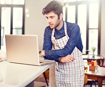 small business owner at a cafe looking at computer