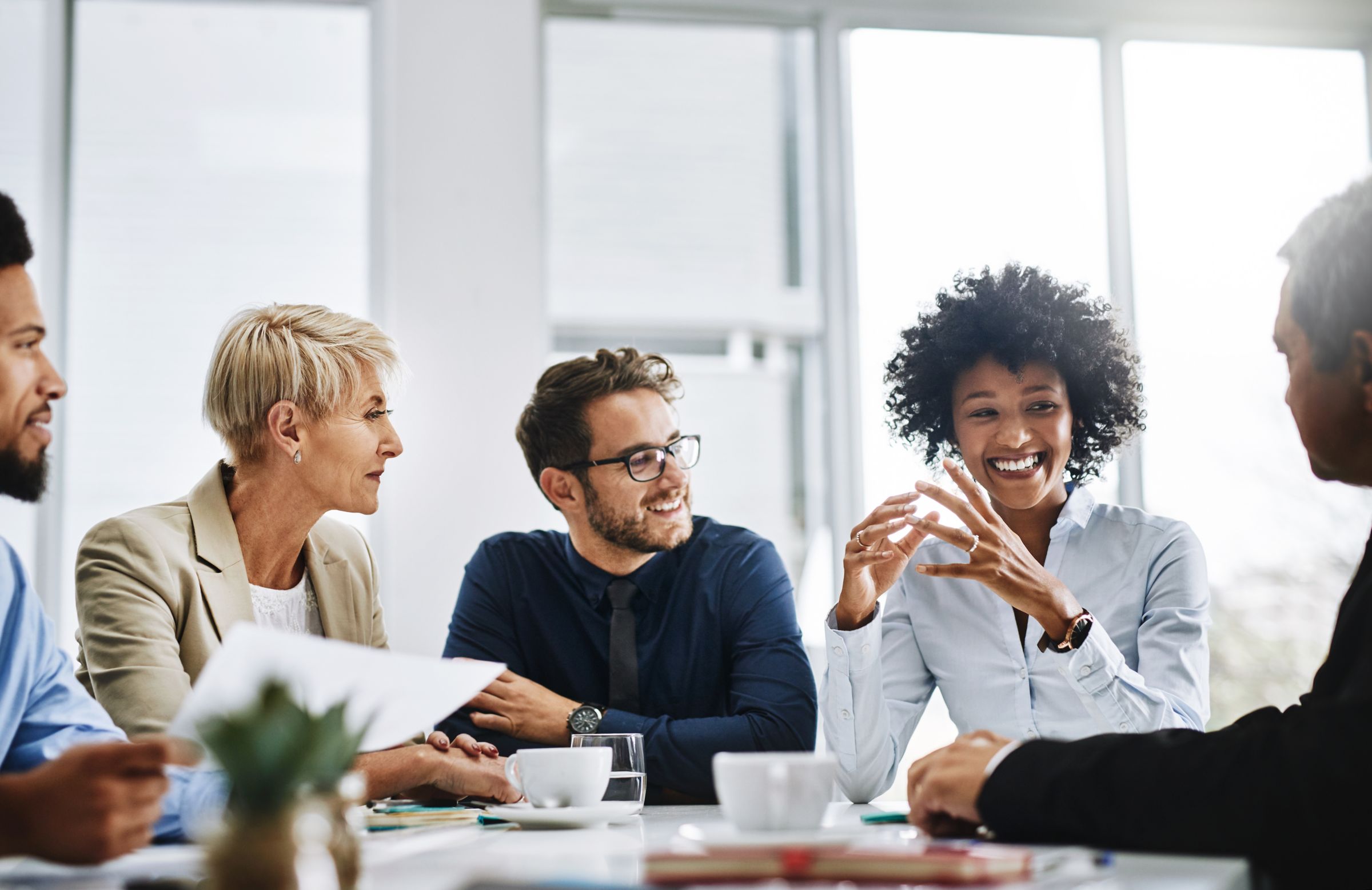  a group of people sitting around a table talking