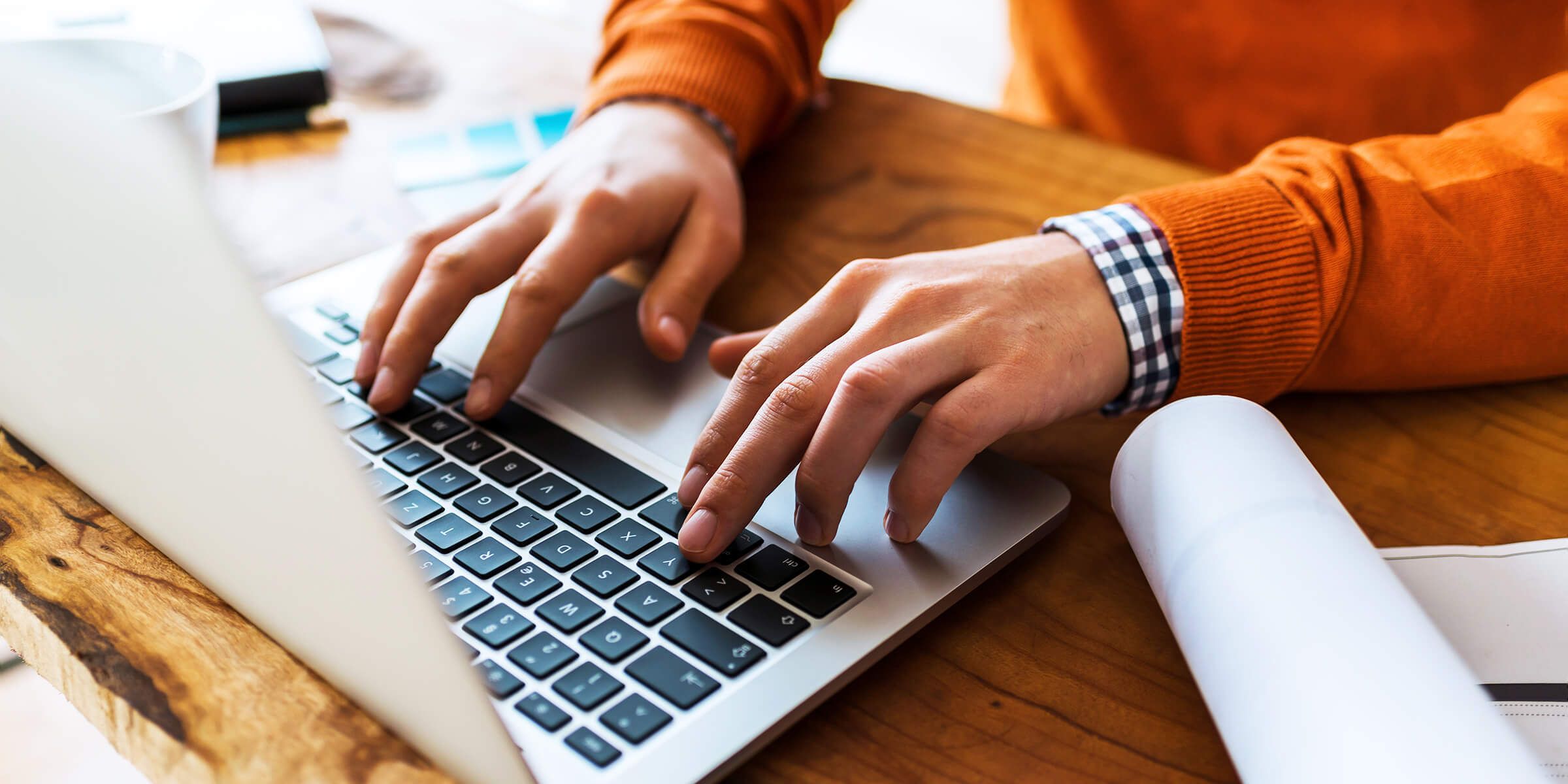 Hands typing on laptop