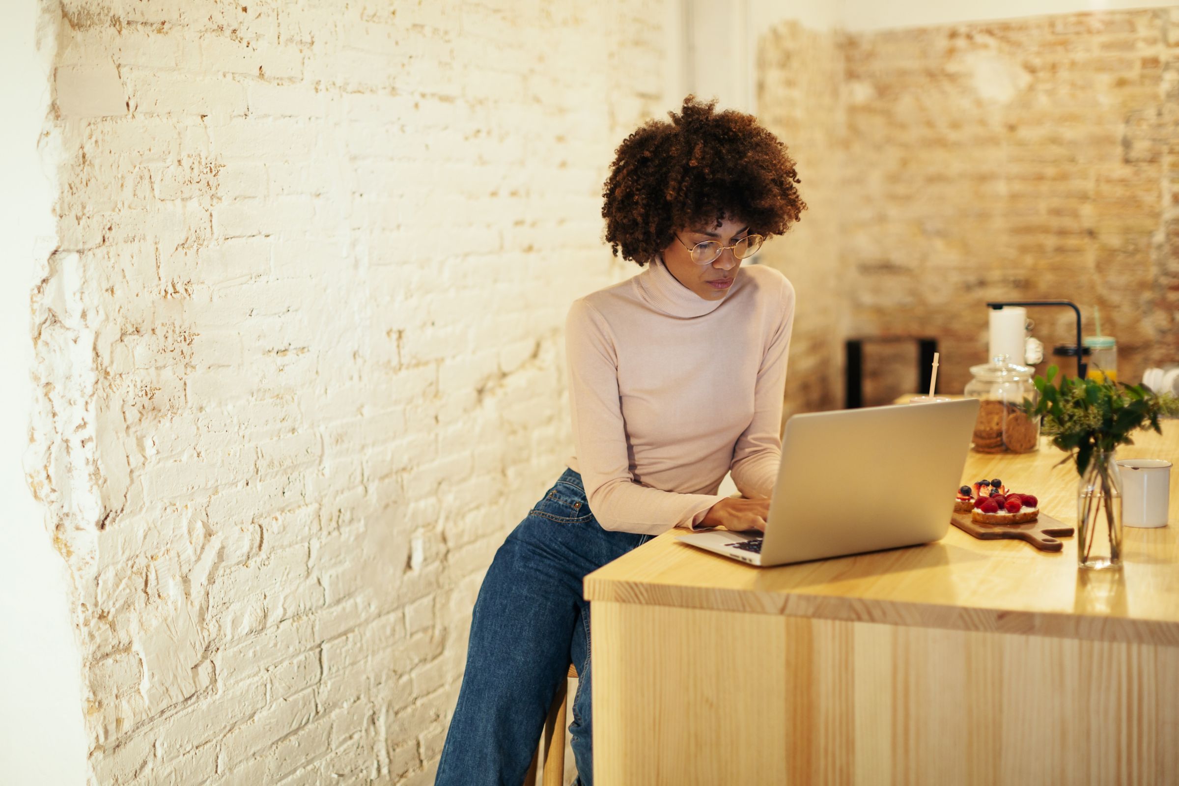 a woman sitting at a table using a laptop