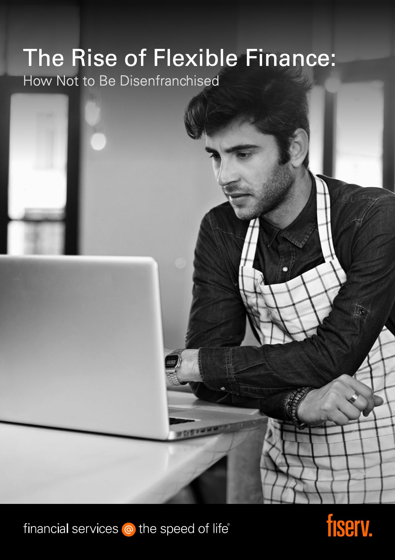 a man in an apron looking at a laptop
