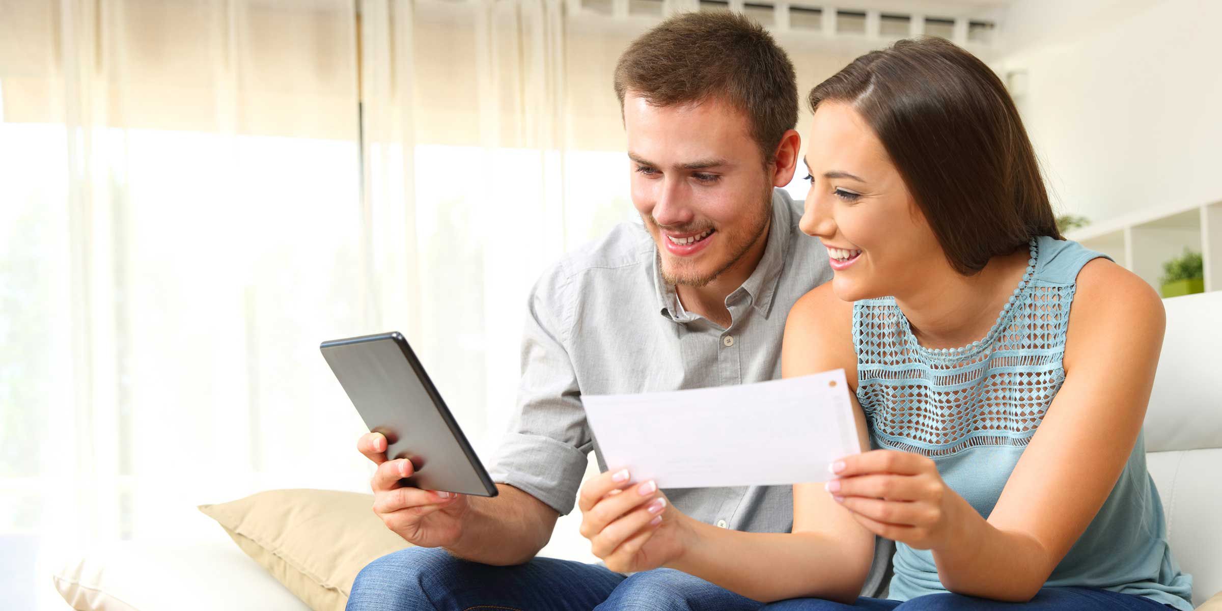 a man and woman looking at a tablet and paper