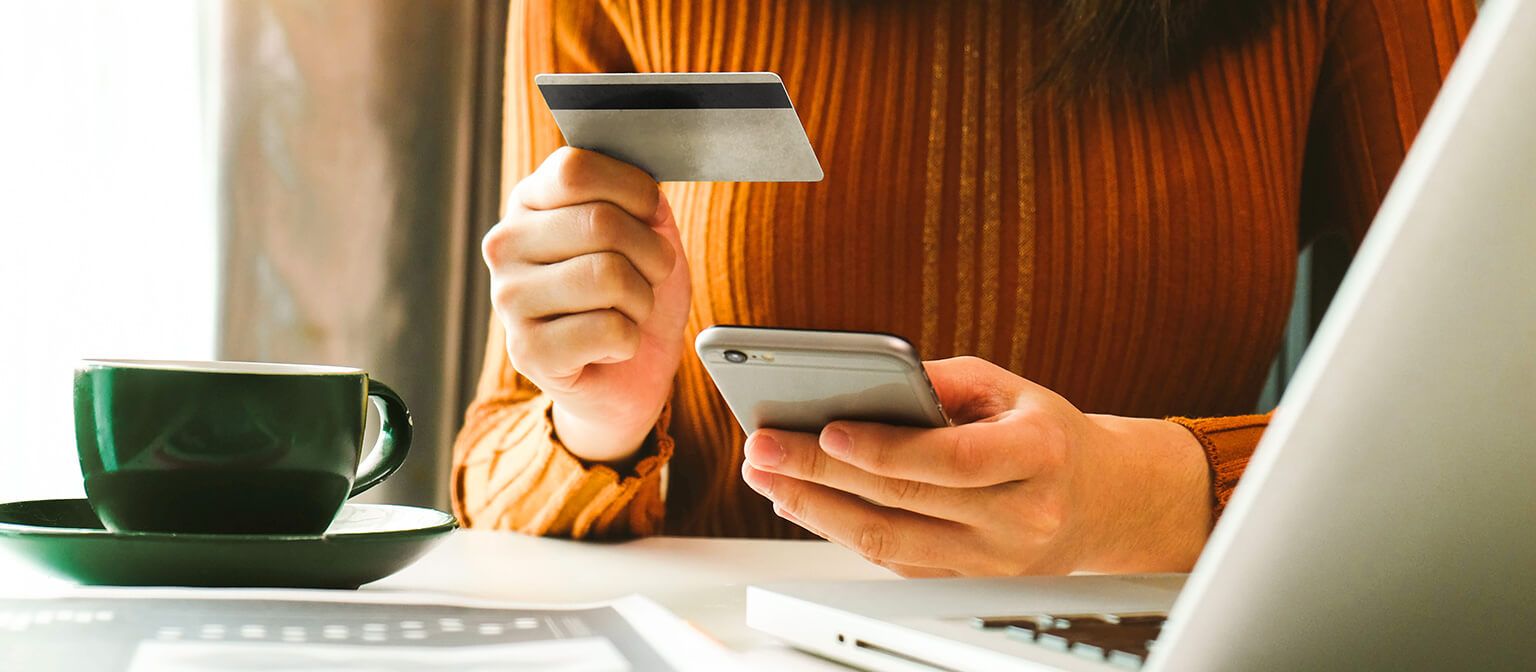 woman holding phone and credit card