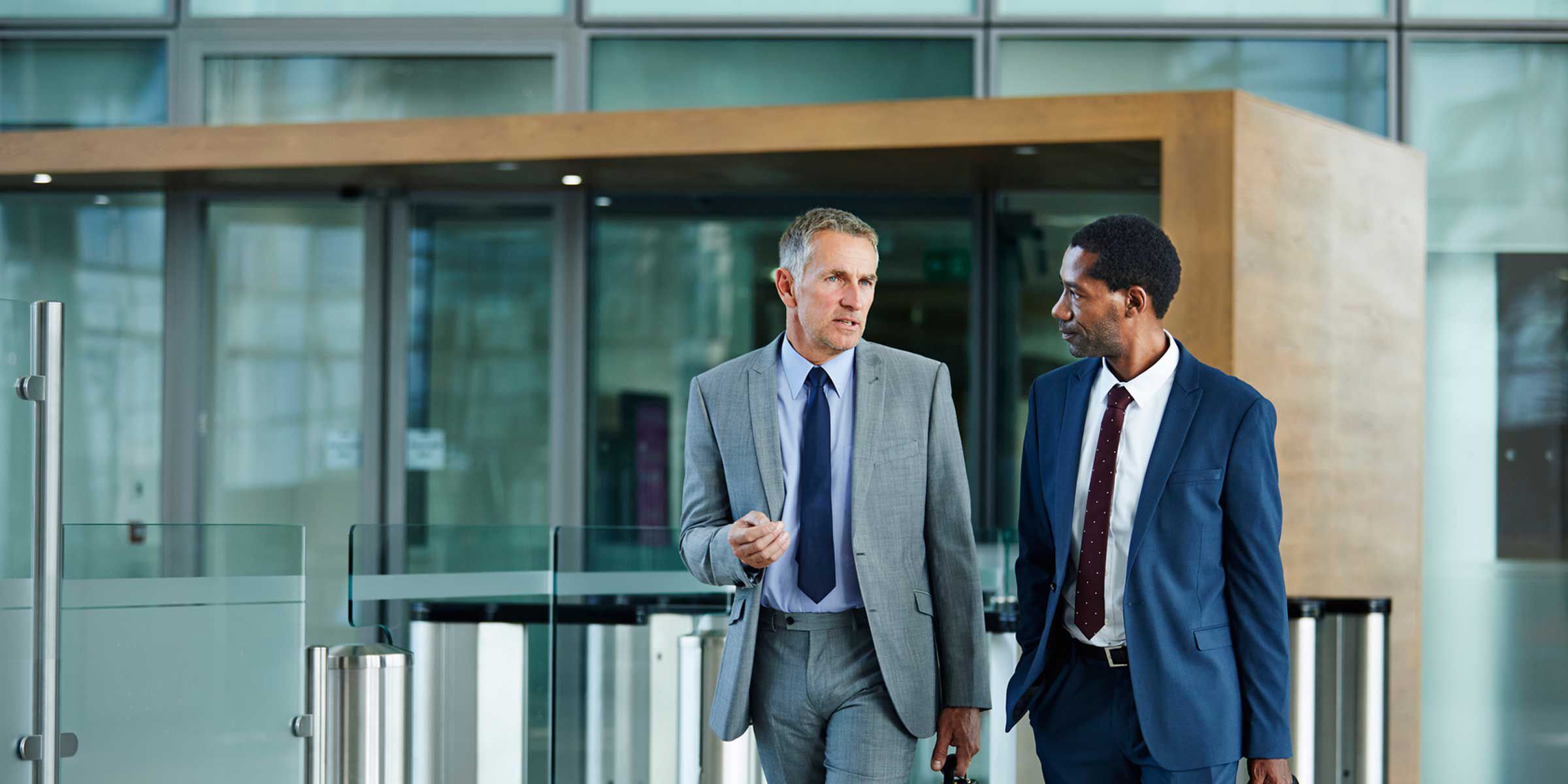 Two businessmen walking outside a modern office building