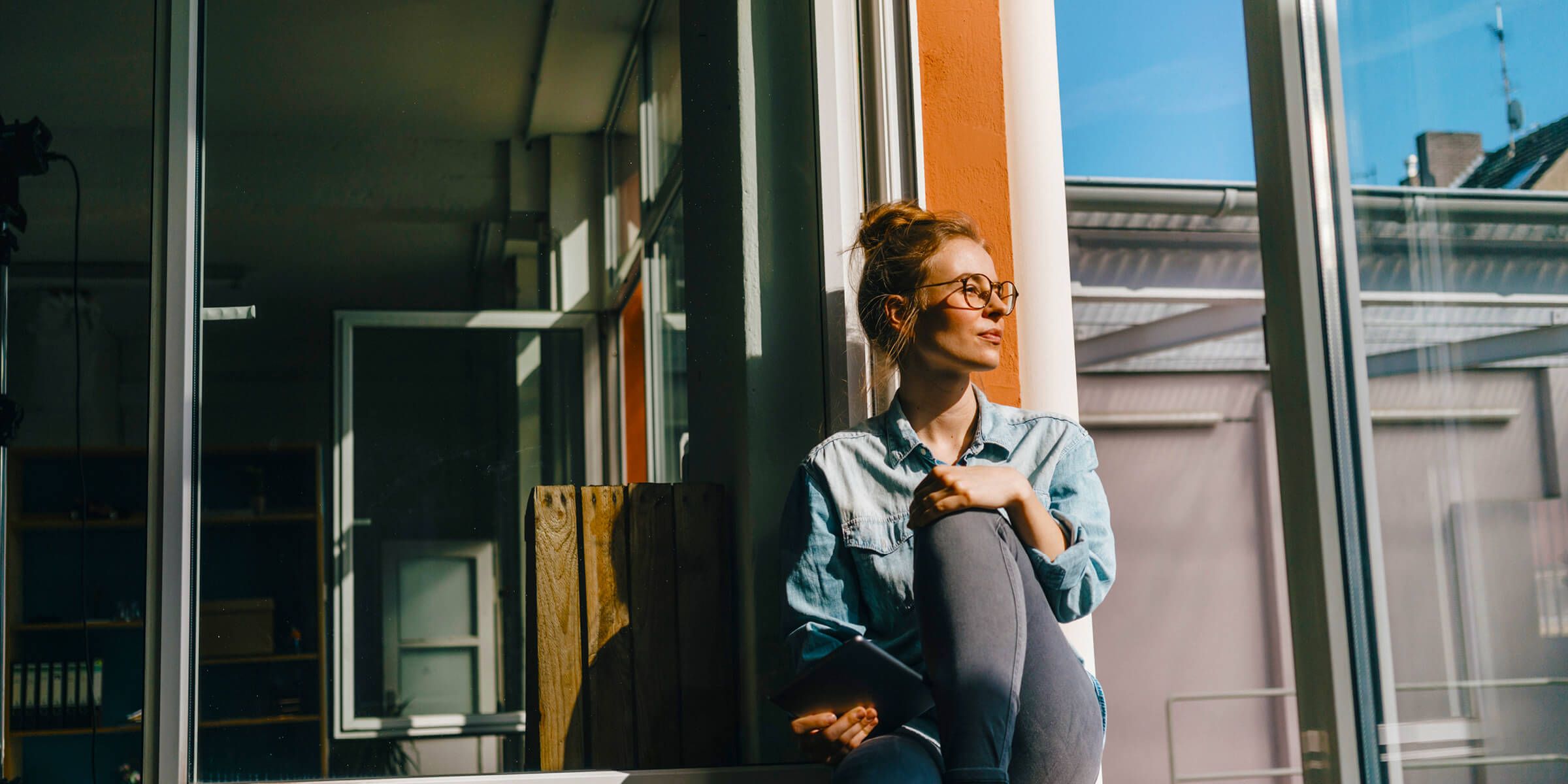Woman sitting in a window and looking outside.