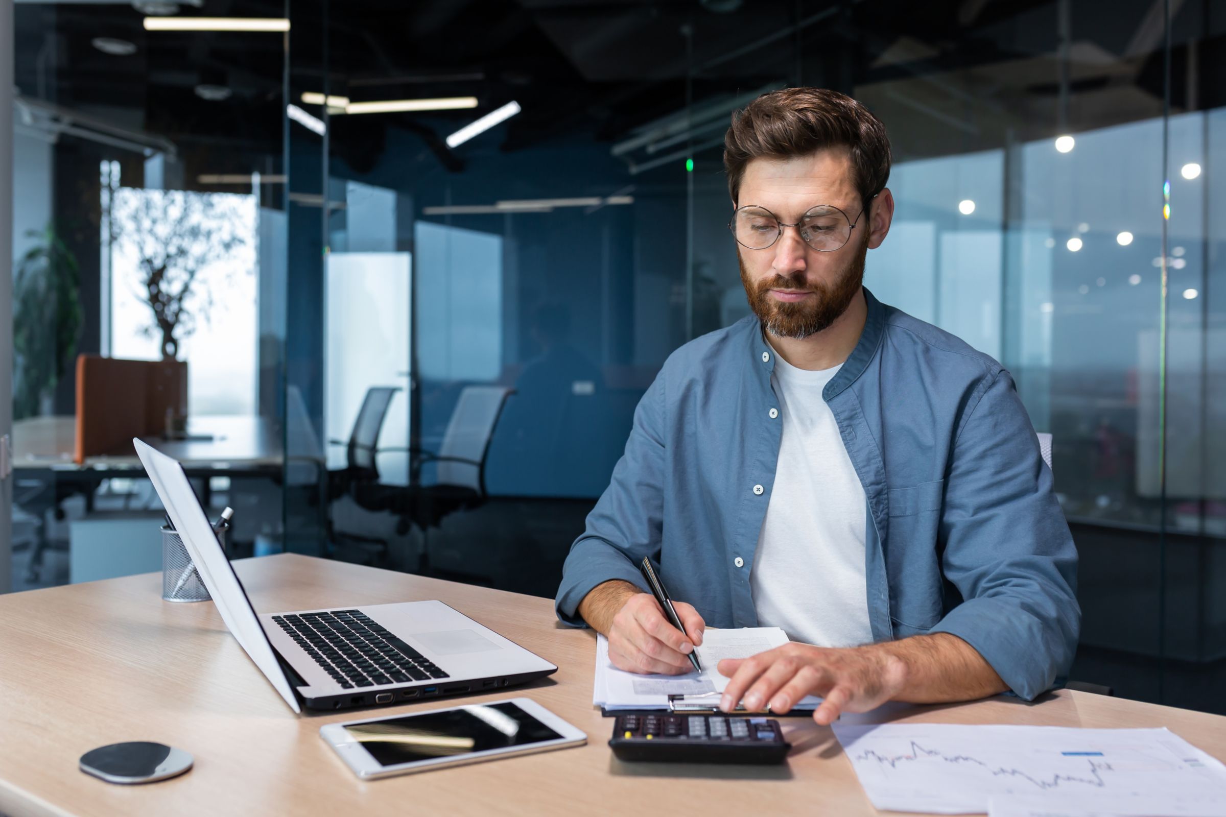 Person sitting at a desk with a laptop, holding a credit card