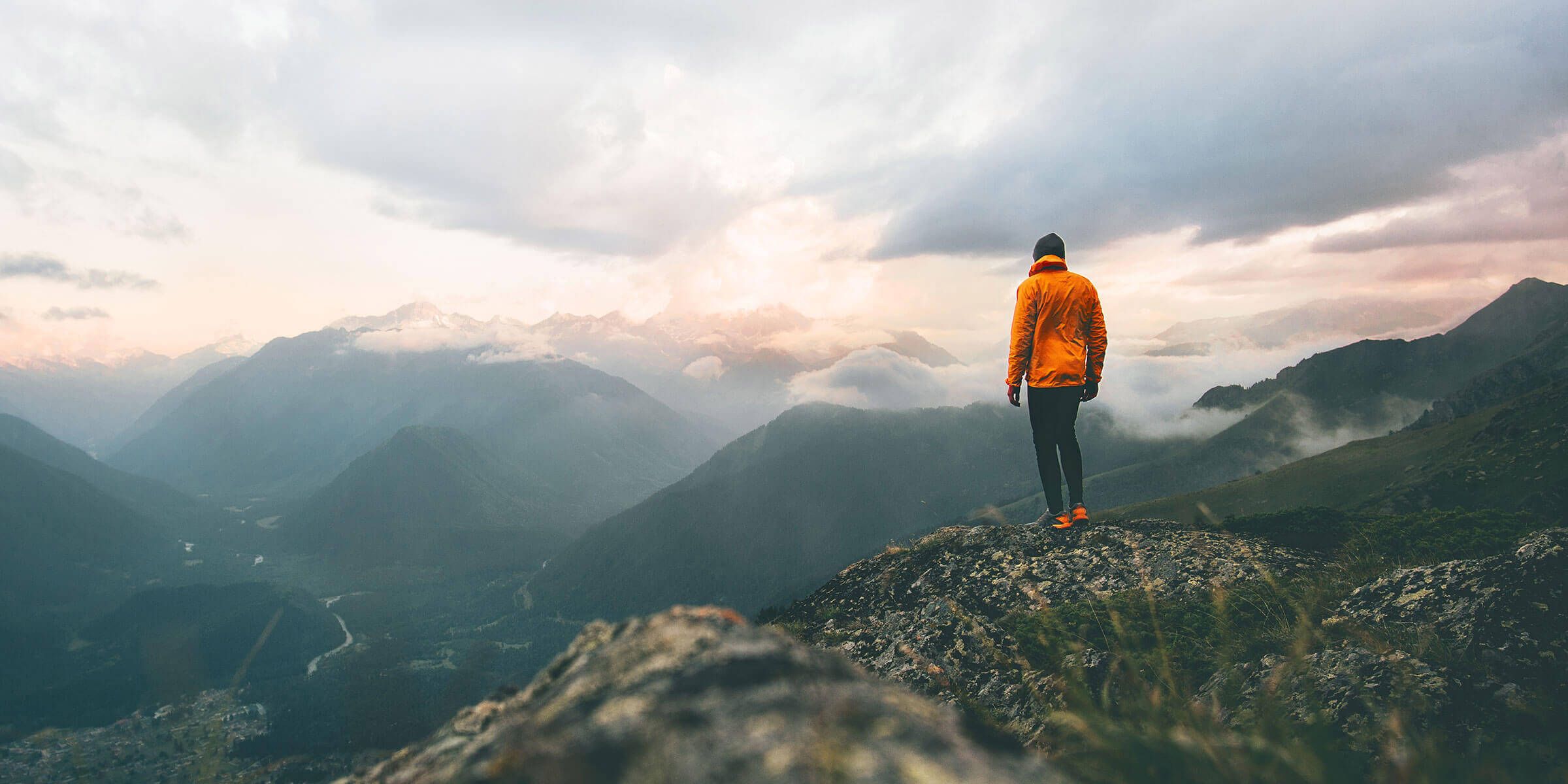 a person standing on a rock looking at mountains