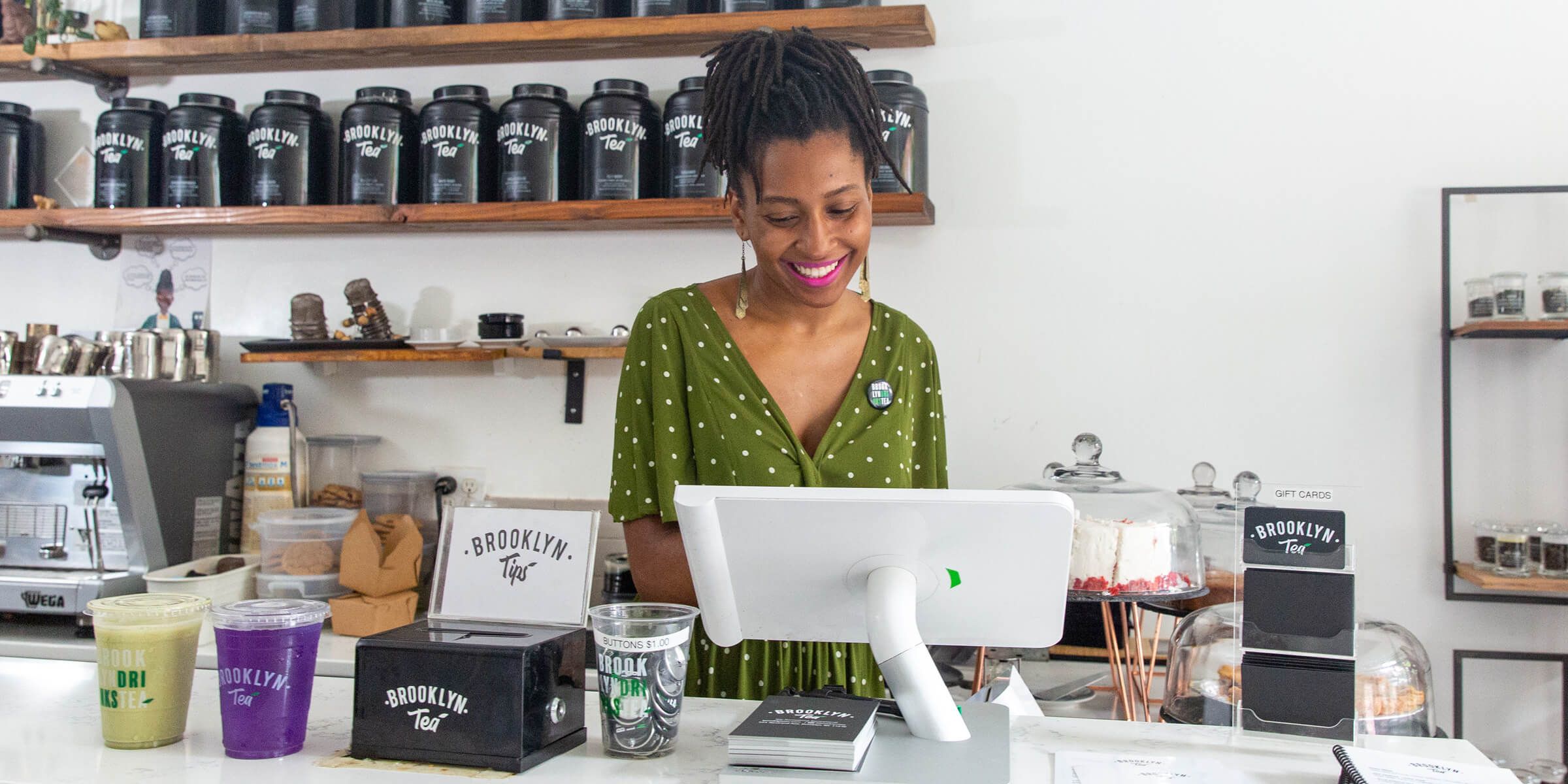 store owner smiling while looking at Clover POS device