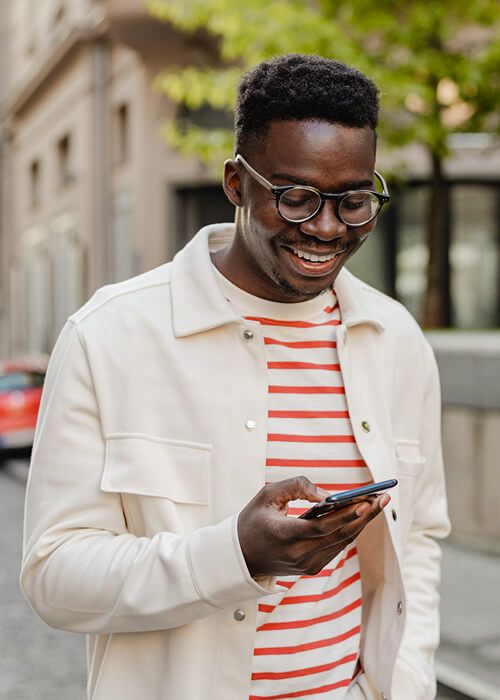 a man smiling while looking at his phone