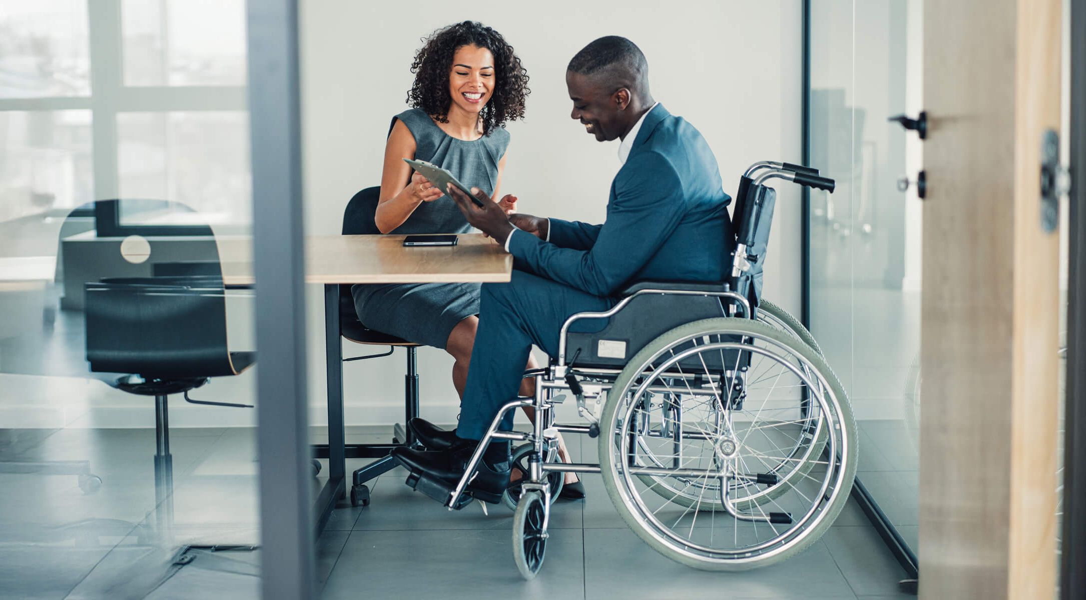 Silhouettes of business commuters on a city street, backlit by the sun
