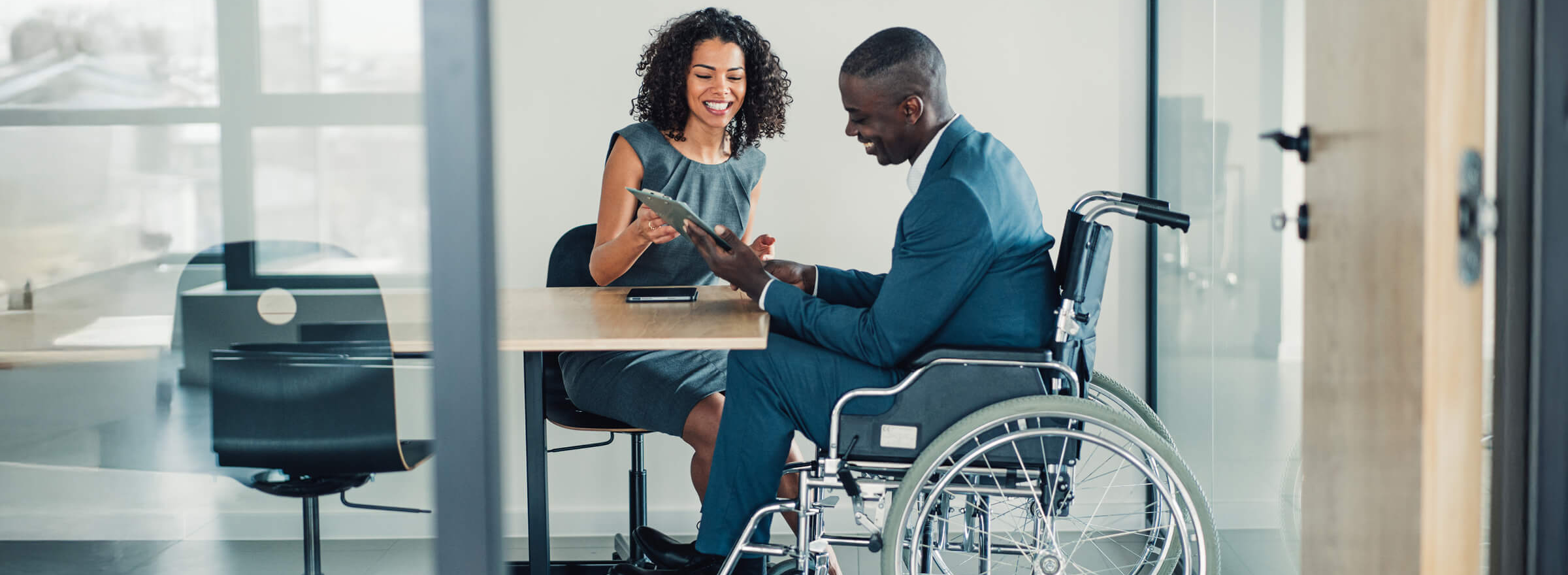 Silhouettes of business commuters on a city street, backlit by the sun