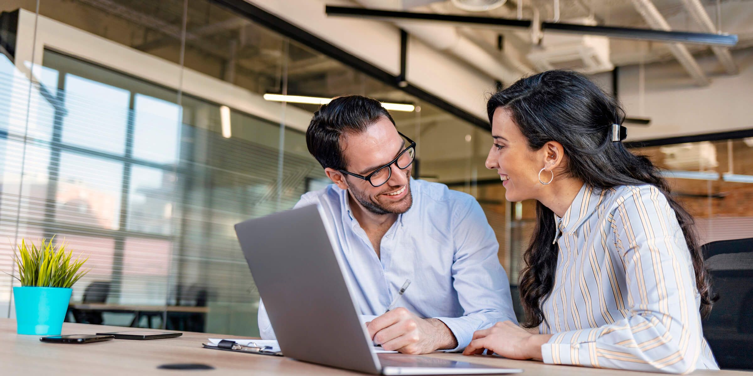 couple smiling while working on a laptop