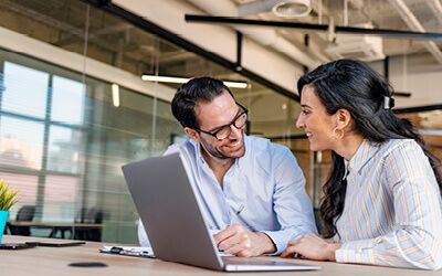 Two people sitting at a laptop