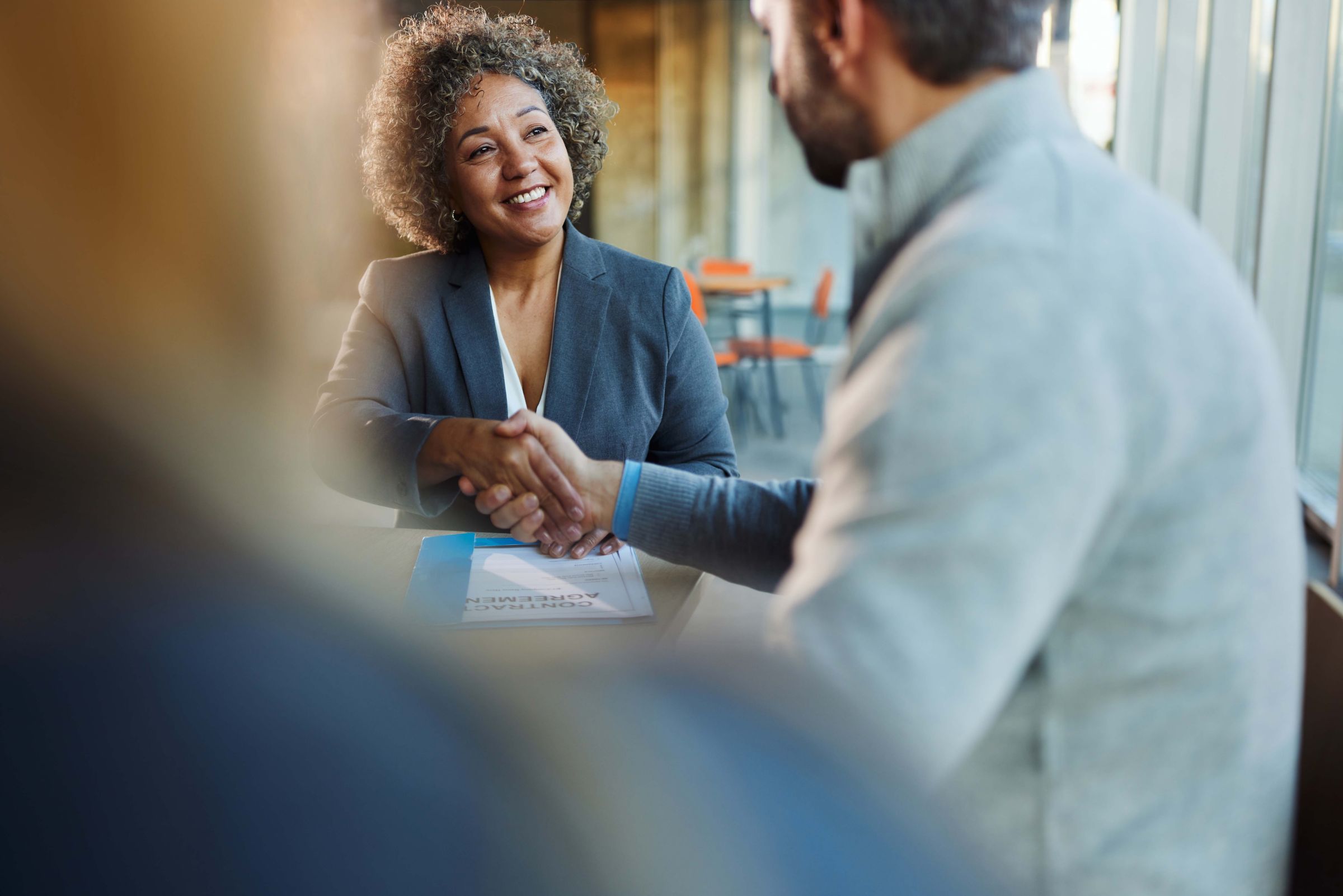two business people smiling and shaking hands