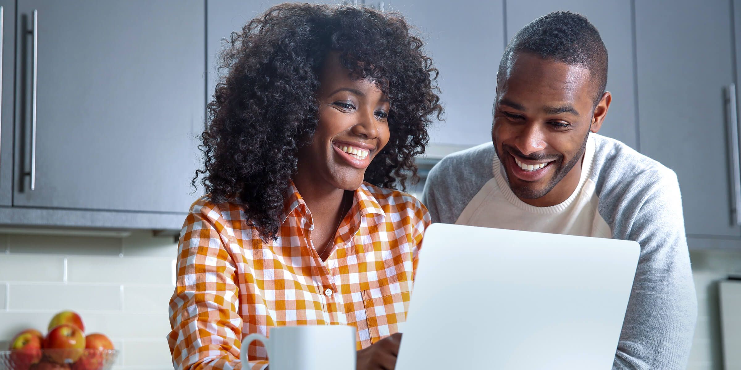 two people looking at a laptop and smiling