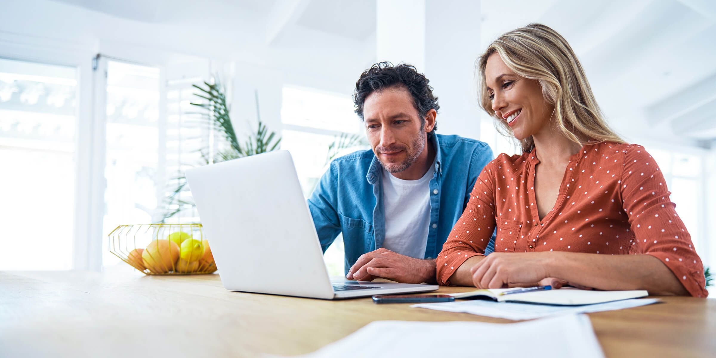 couple smiling looking at laptop