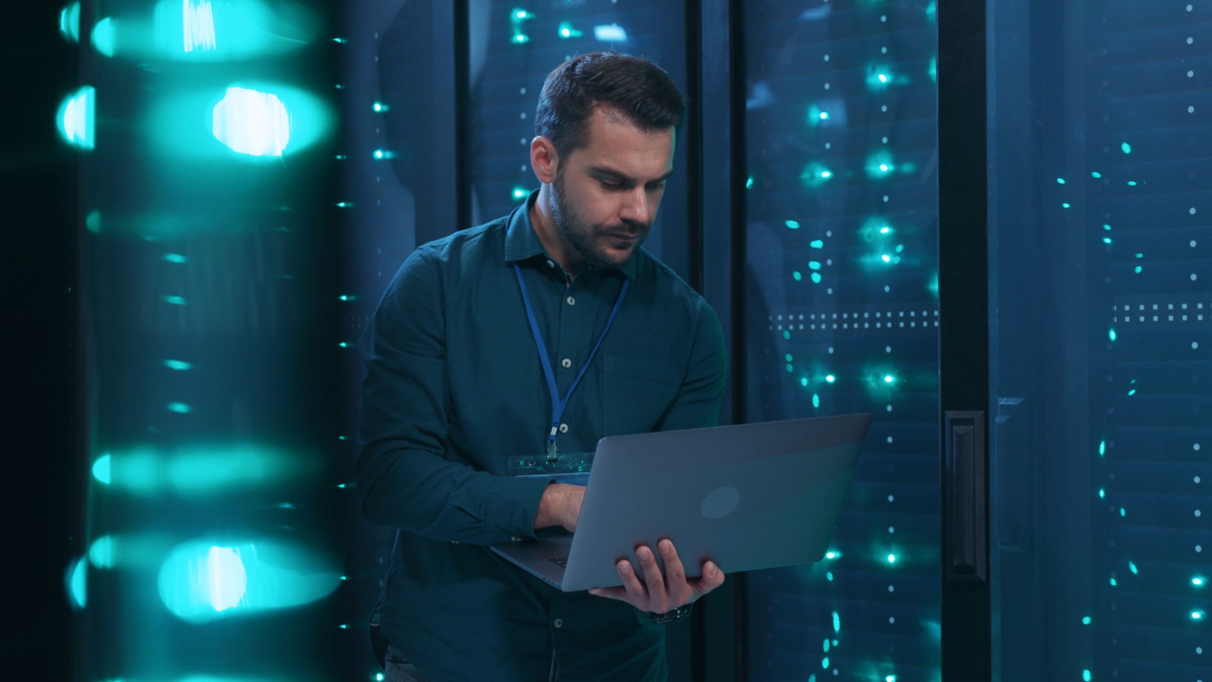 IT person holding laptop in server room