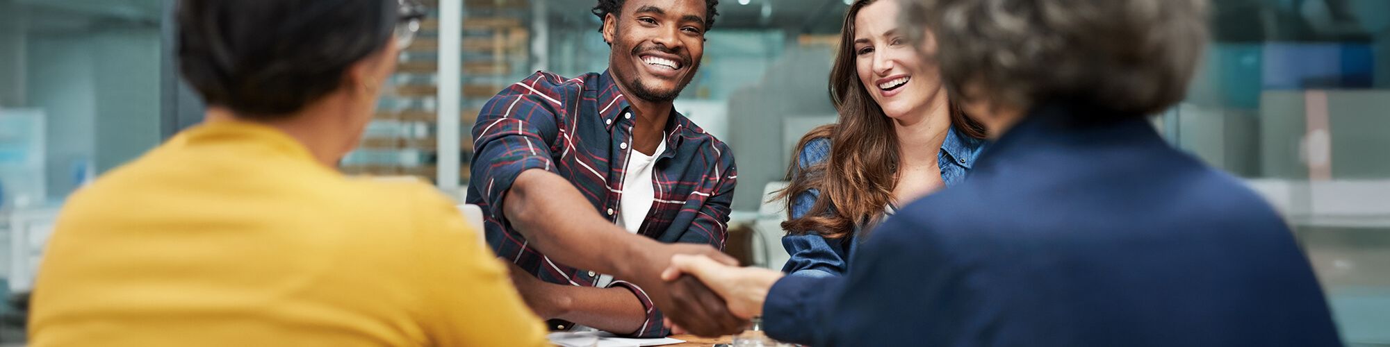 People shaking hands across the table.