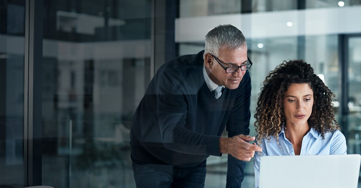 a man and a woman looking at a laptop