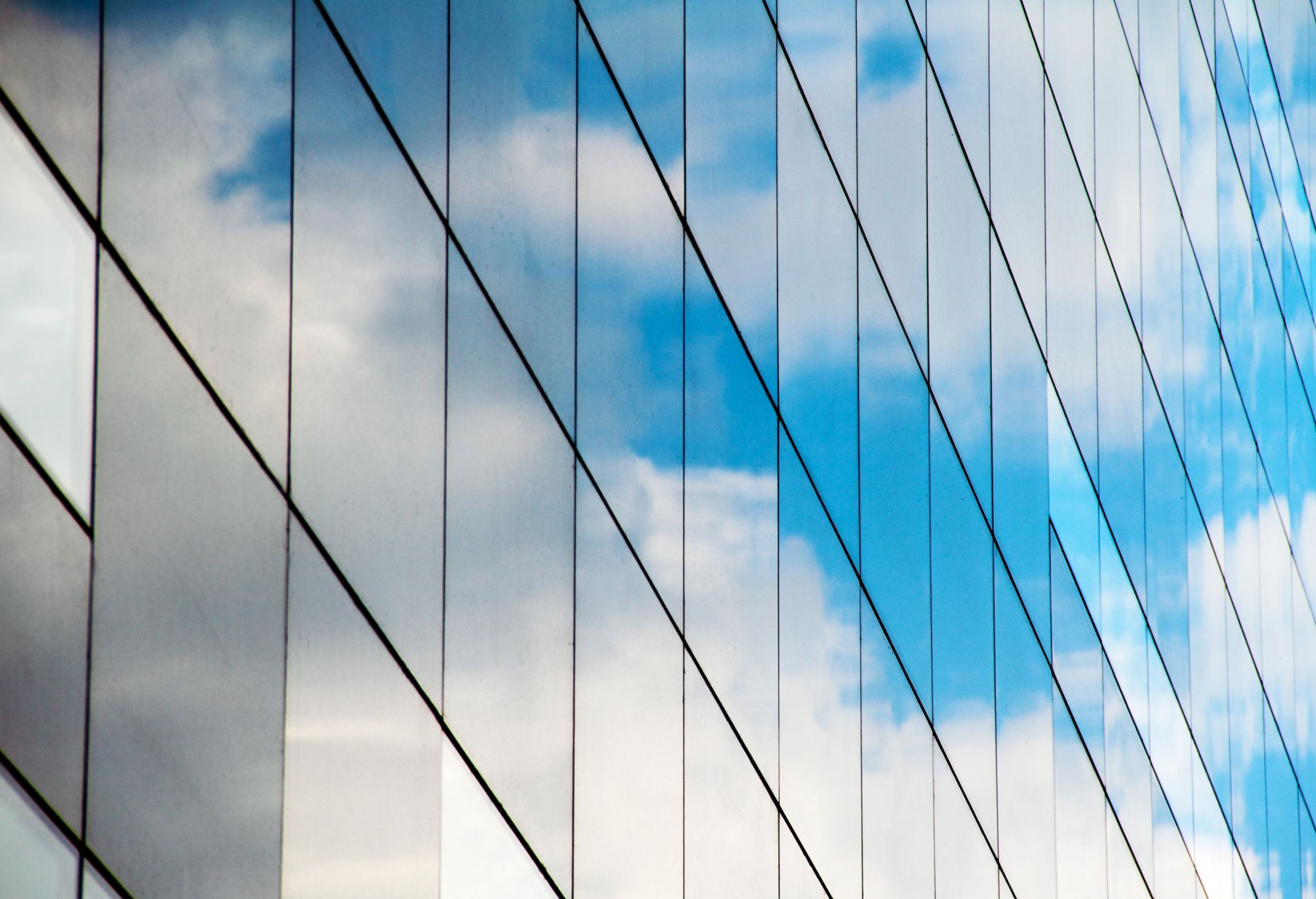 side of a building with clouds reflecting