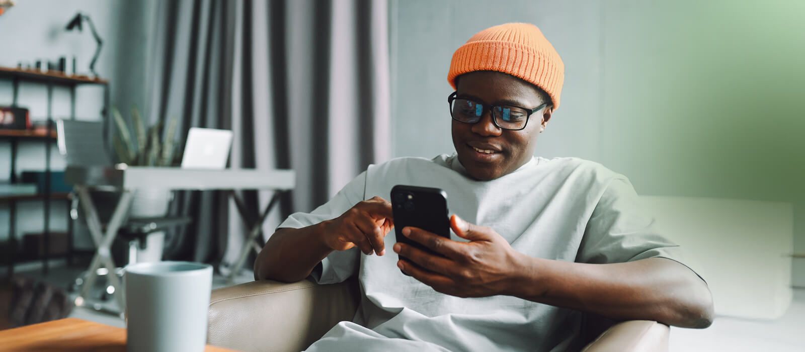 Online shopping. A man makes purchases on the Internet using a smartphone at home in the living room. Comfortable shopping at home. A man makes purchases on the Internet using a smartphone at home in the living room.