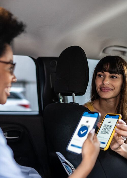 a woman scans a QR code on a phone in a car