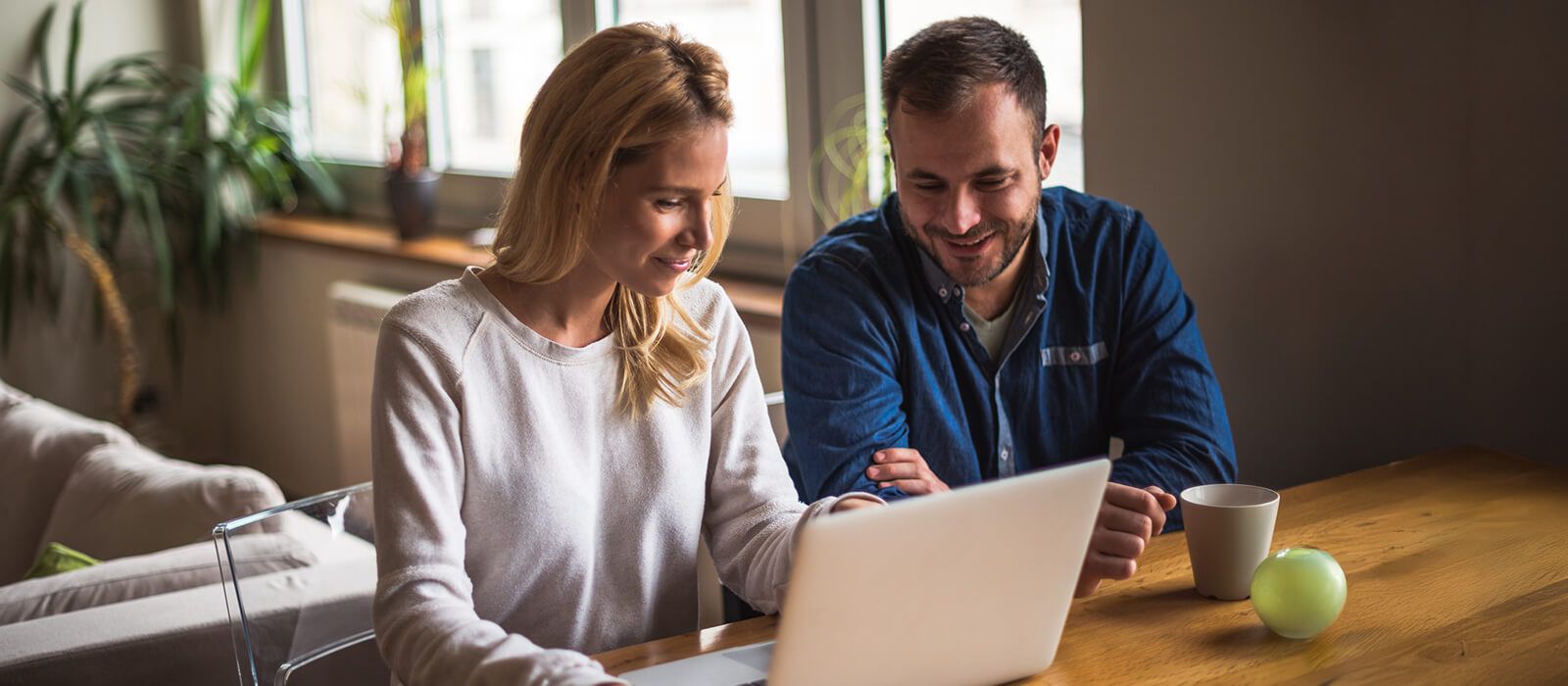 a man and woman looking at a laptop
