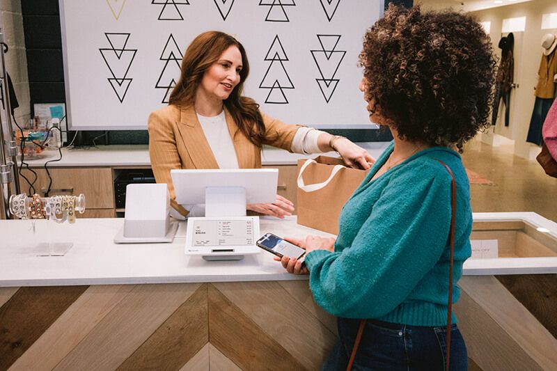 women purchasing item with Clover in boutique