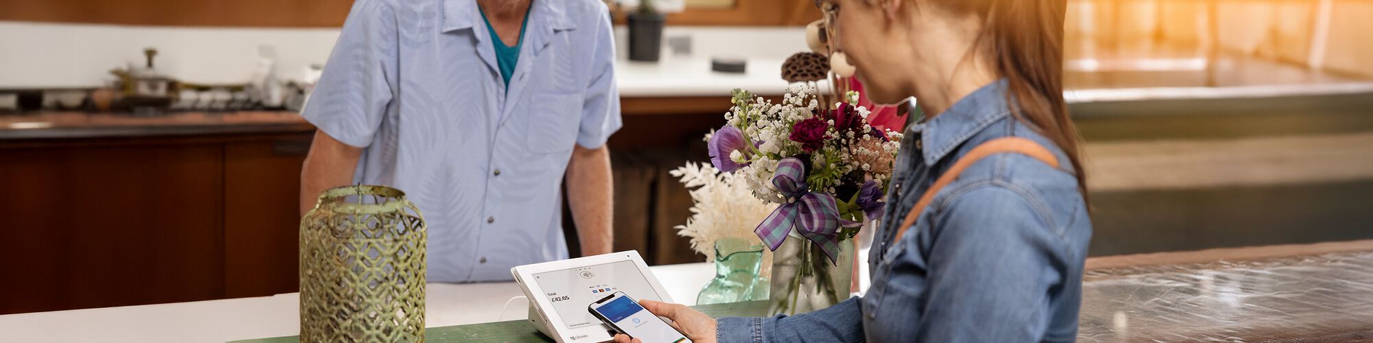 woman paying with phone at store register