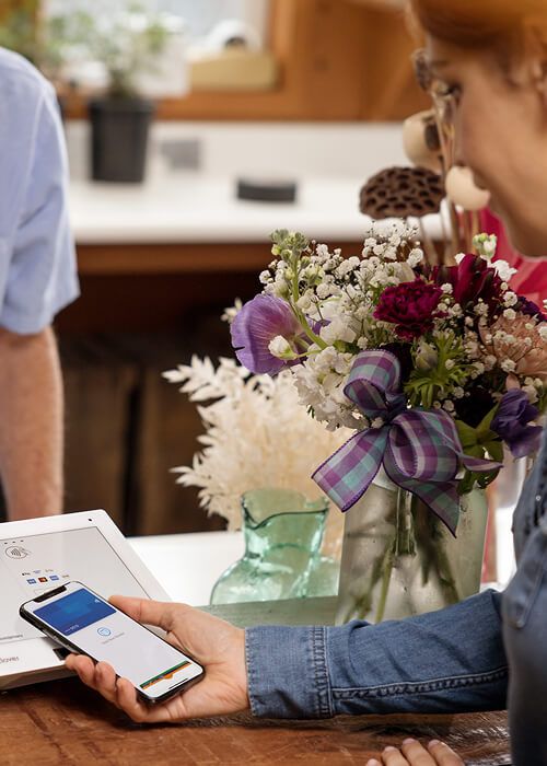 woman paying with phone at store register