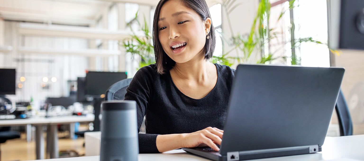 Asian woman using virtual assistant device