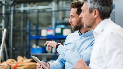 two businessmen sitting together looking at computer screen