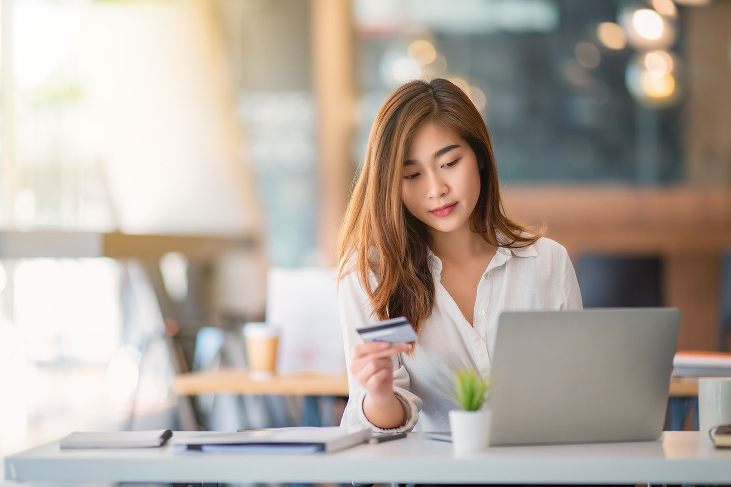 woman holding a credit card at a laptop