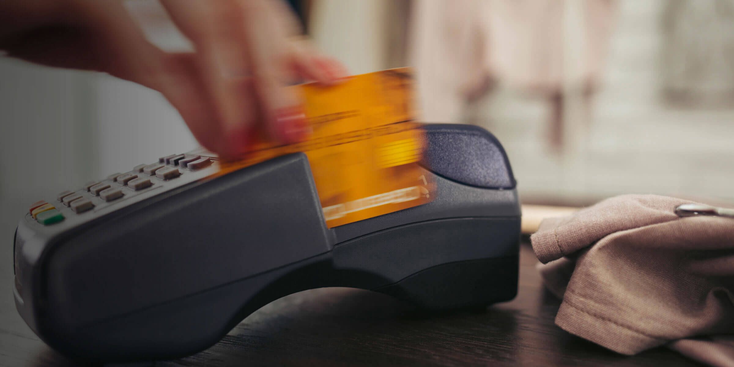 a person swiping an electronic card through a machine