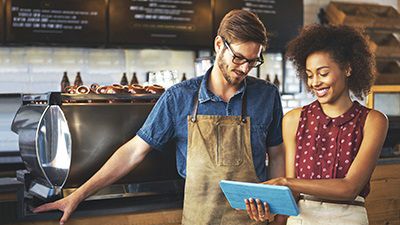 Man and women business owners looking at tablet